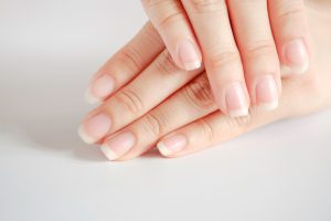 Gros plan de belles mains et ongles de femme sur fond blanc, Concept de soins de santé de l'ongle.